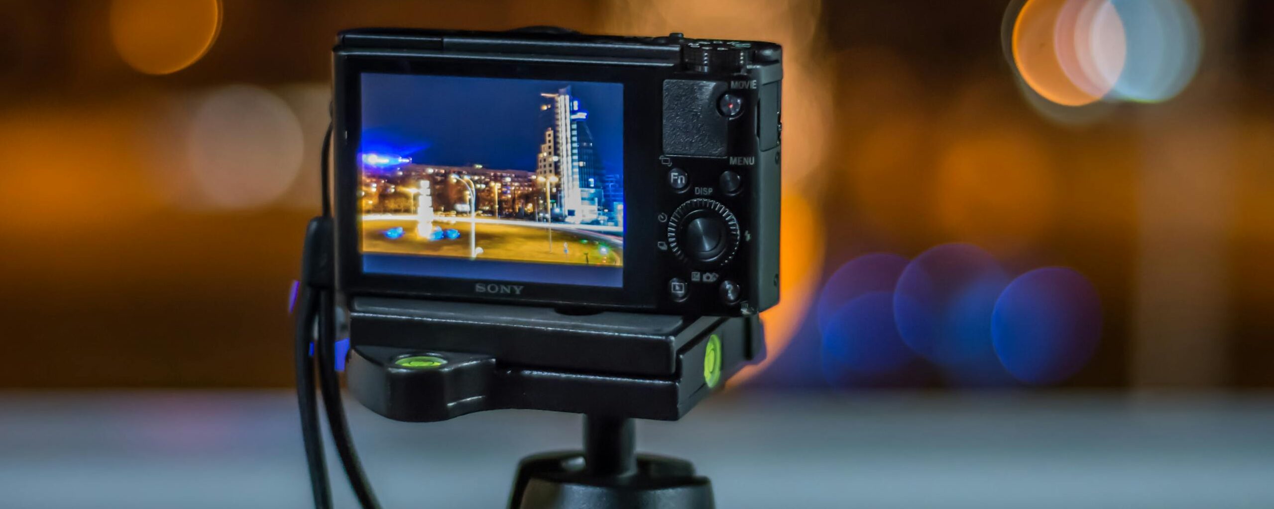 Photograph of a DSLR capturing a cityscape at night with a beautiful bokeh background.